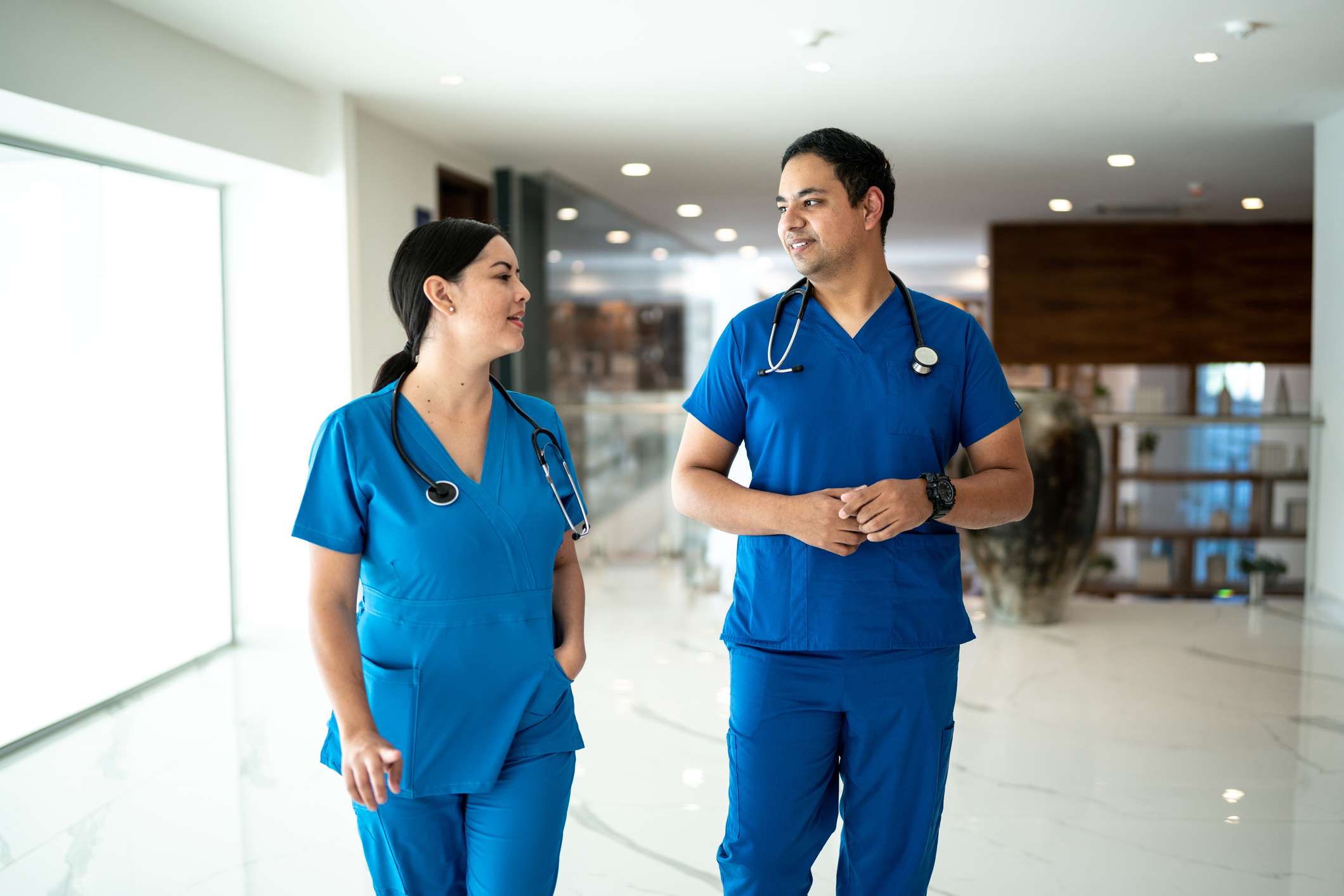 Nurse coworkers walking and talking on the hospital